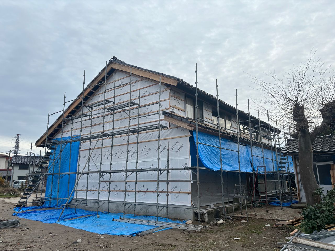 減築すると元々内部構造だった箇所が外部になるため、基礎の増設、構造体の補強、屋根の補修が必要になります。写真は減築後の様子。地面のブルーシートが敷いてある箇所が大体の減築範囲。（富山市） 